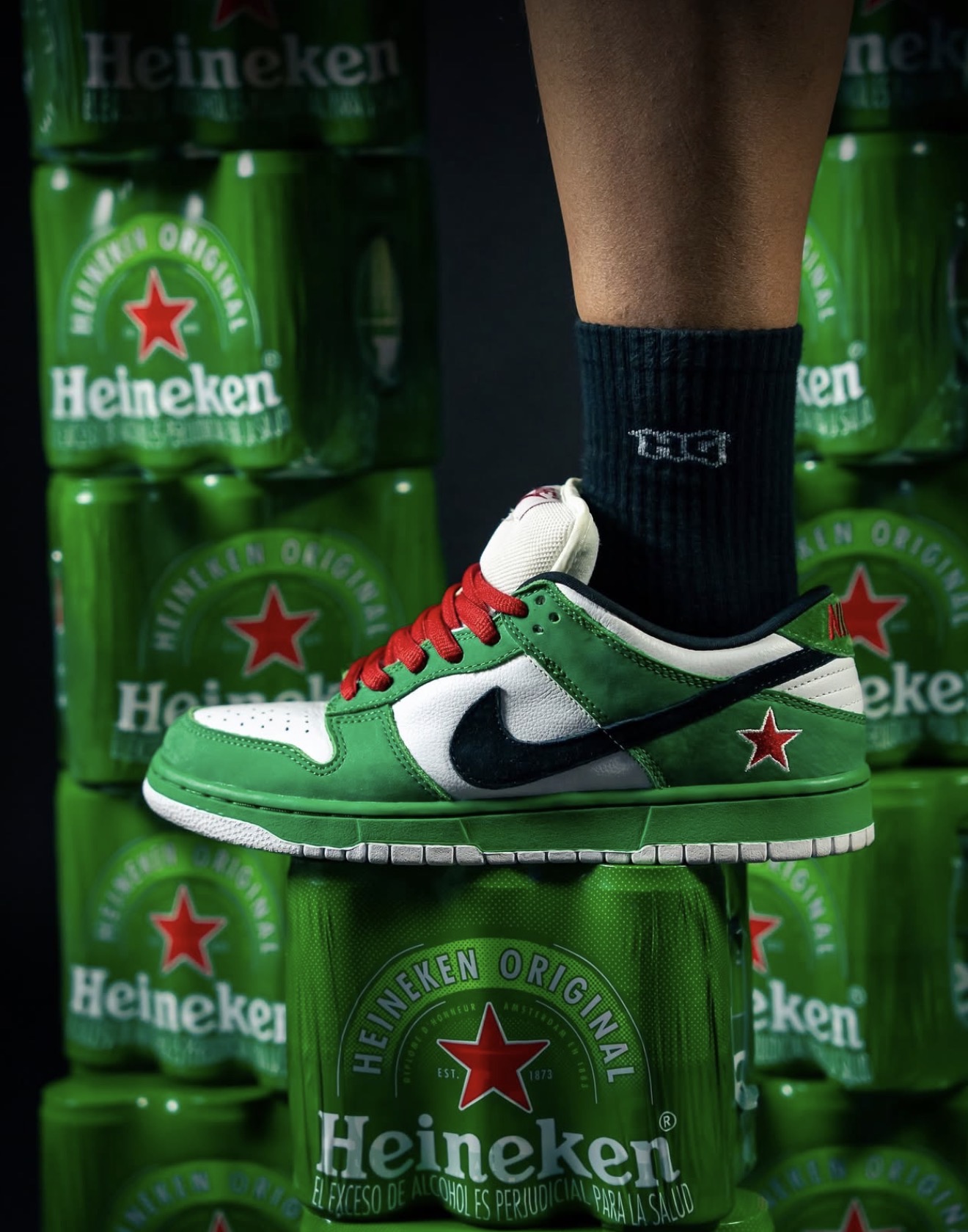 Nike SB Dunk Low Heineken sobre una pared de latas verdes — archivo Holy Grail