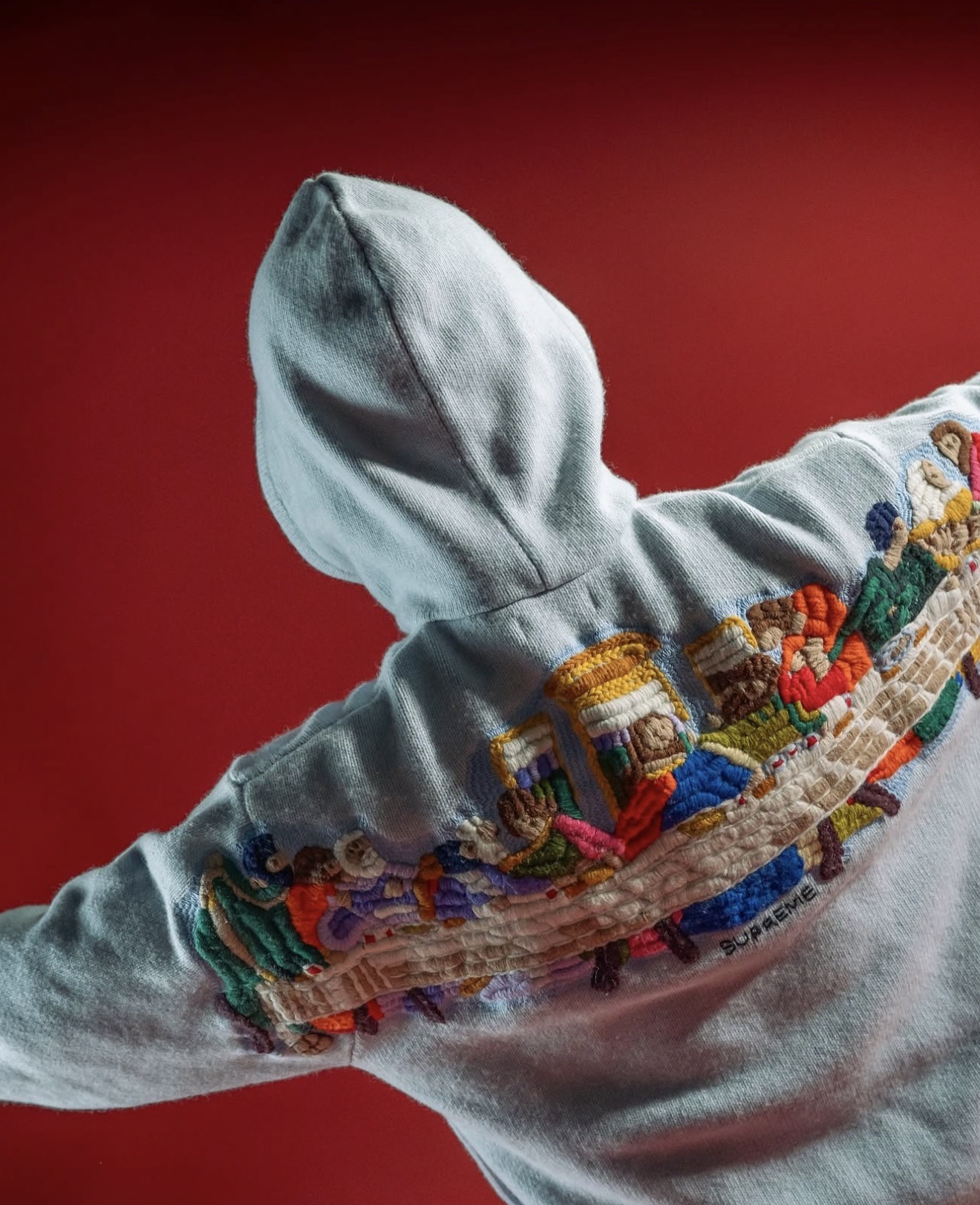 Hoodie gris de Supreme con bordado a color sobre fondo rojo — Holy Grail