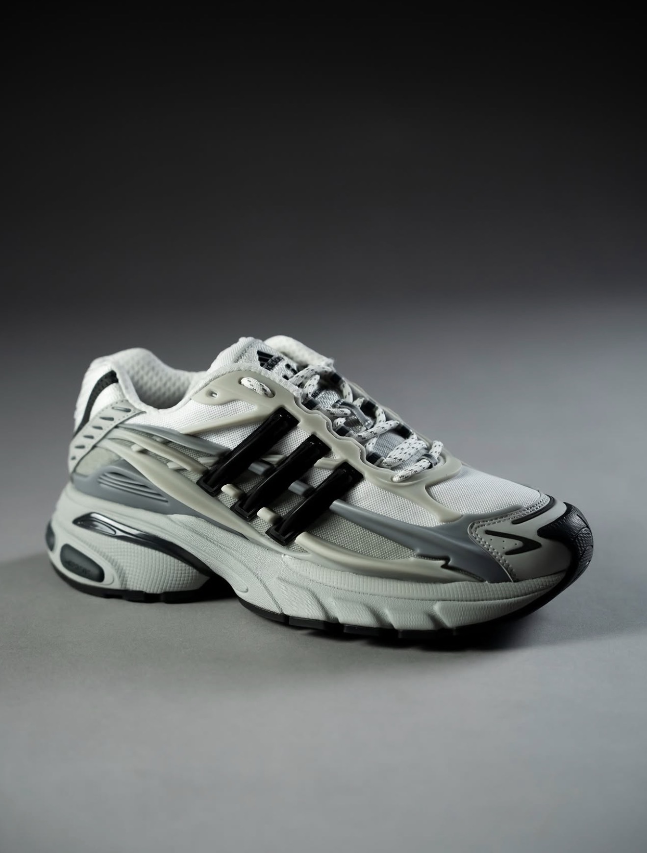 Zapatilla adidas blanca y gris en luz de estudio — Holy Grail
